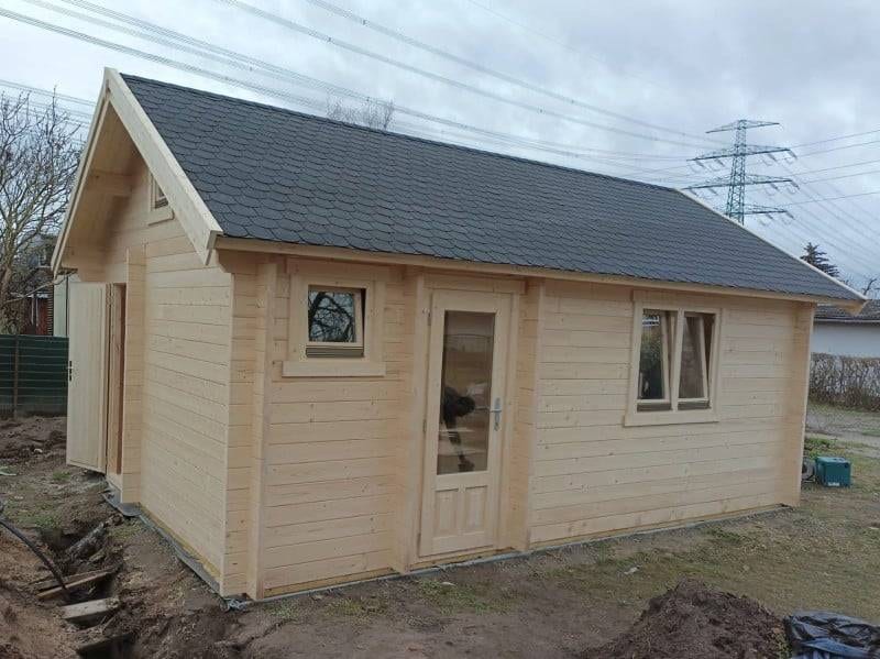 Gartensauna Projekt Seitenwand Gardasee: Holzhaus mit Fenster und Tür, ideal für Entspannung im Garten.