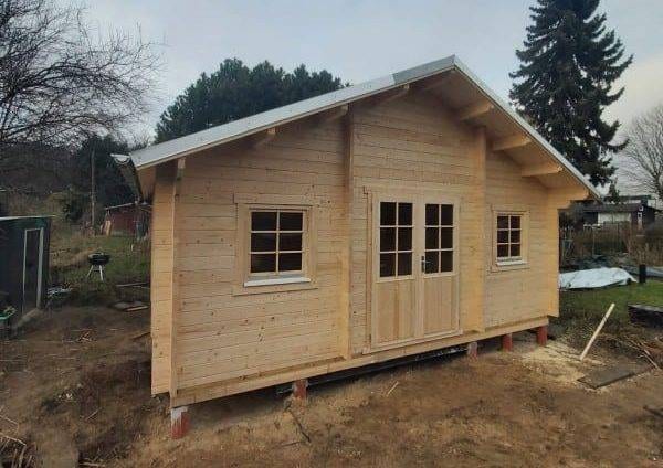 Blockhaus Bodensee: Holzhütte mit Fenstern und Doppeltür. Gartenhaus im Grünen, Holzbauweise.