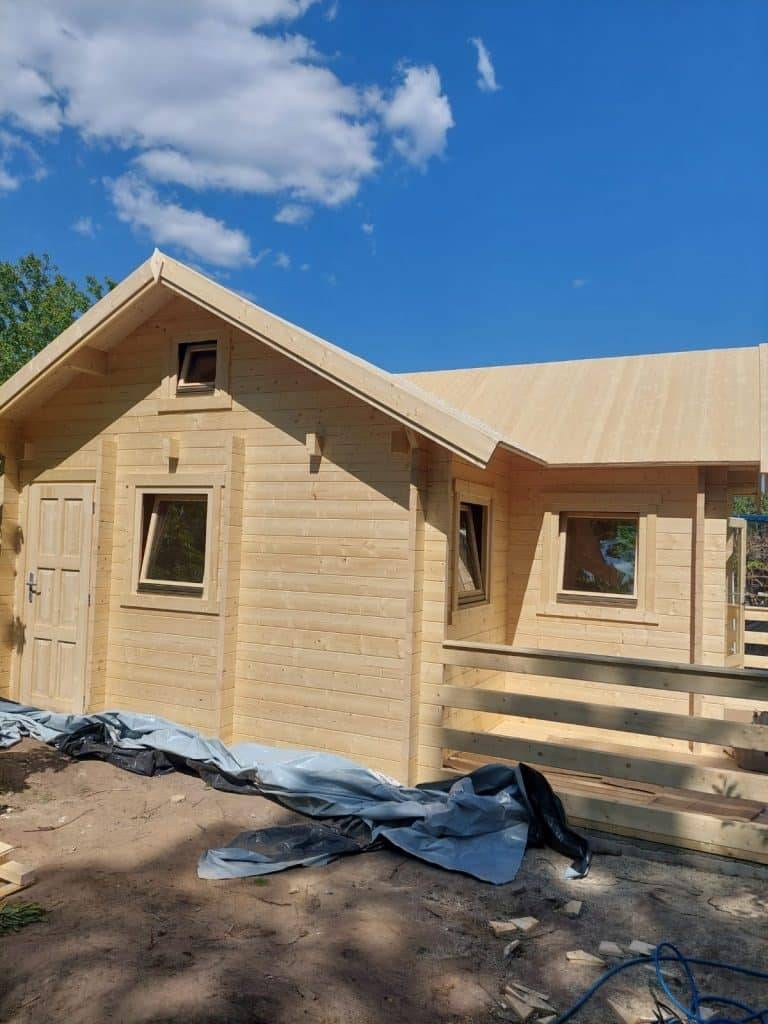 In einem Waldgebiet wird eine Blockhütte gebaut.