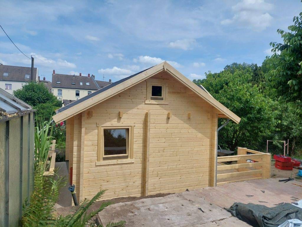 In einem Hinterhof wird ein Holzschuppen gebaut.