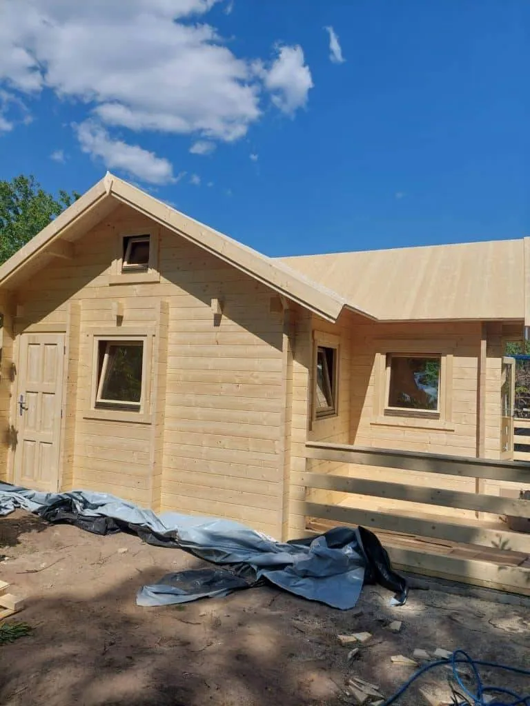 In einem Waldgebiet wird eine Blockhütte gebaut.